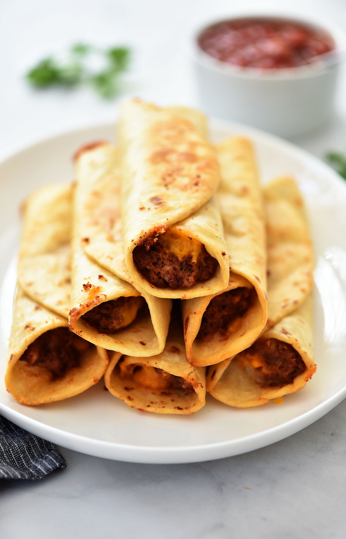 Crisp Bean Burritos wrapped in tortillas on a white plate