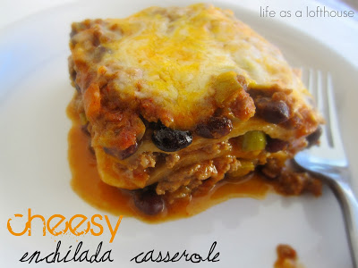 Cheesy Enchilada Casserole on a white dish with a fork