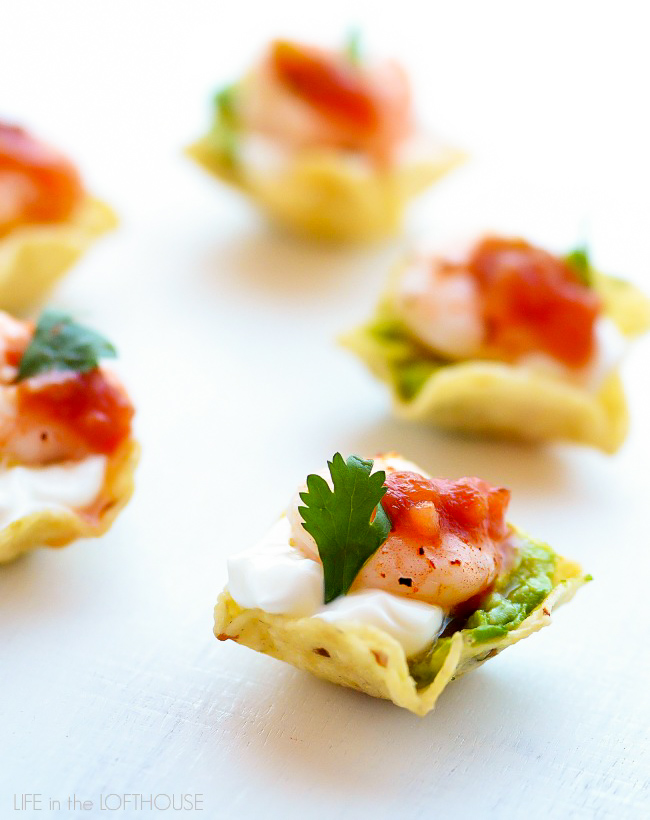 Delicious shrimp covered in a honey lime marinade placed on a scoop tortilla chip with sour cream and guacamole make up these shrimp taco bites. Life-in-the-Lofthouse.com