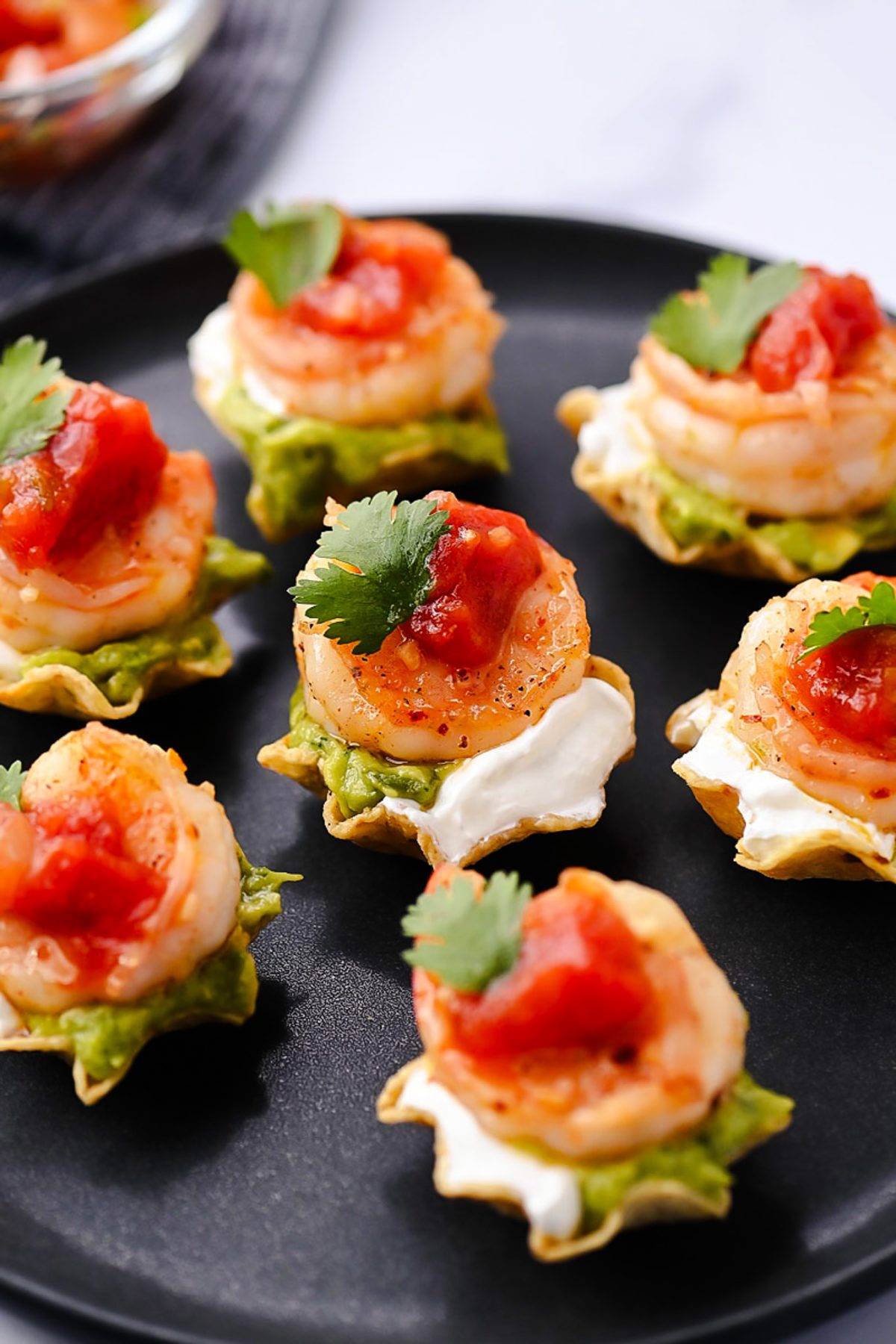 Juicy, marinated shrimp in a tangy honey-lime sauce are nestled in crunchy tortilla scoops and topped with smooth avocado, cool sour cream, and vibrant fresh salsa.