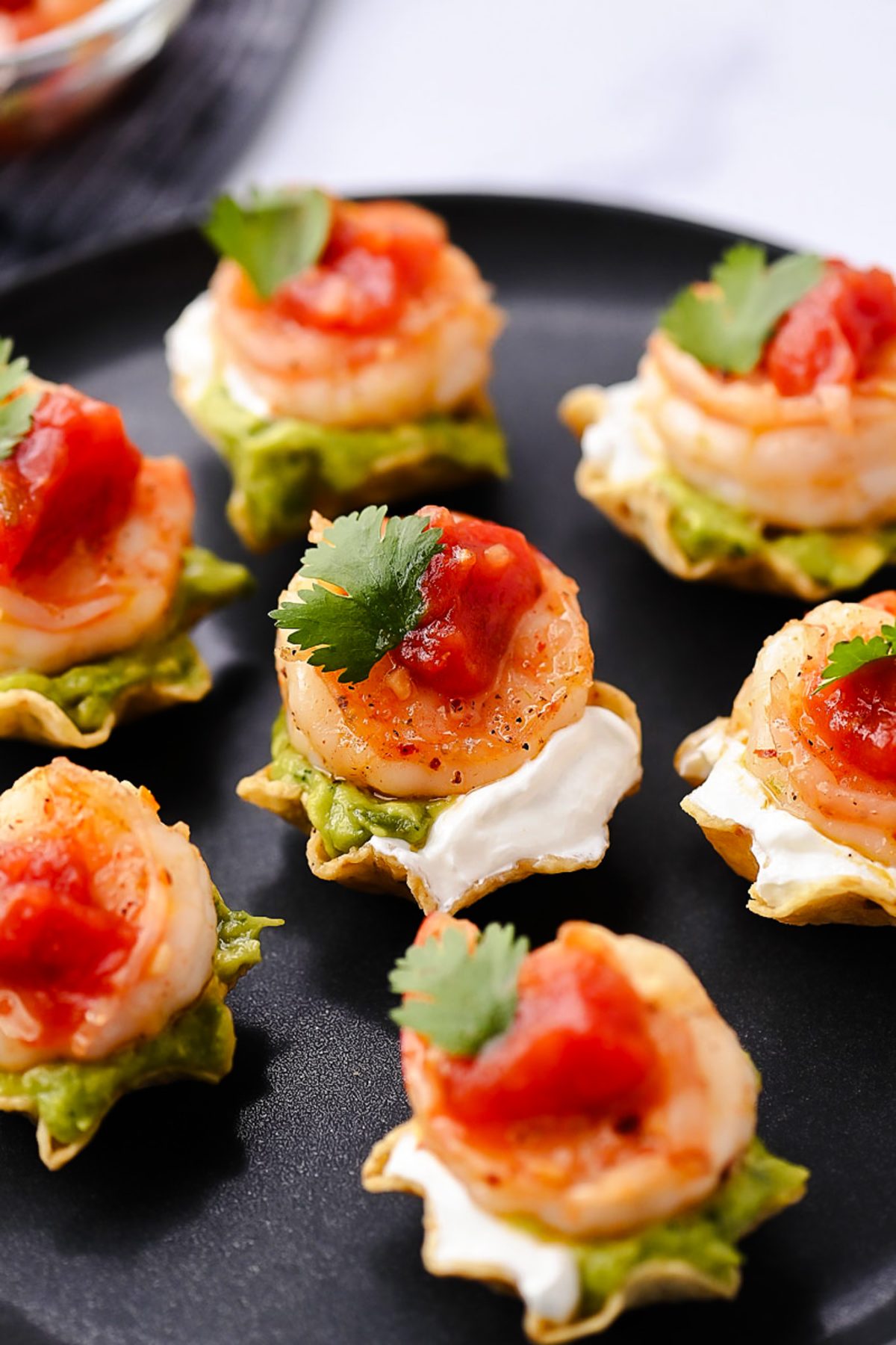 Juicy, marinated shrimp in a tangy honey-lime sauce are nestled in crunchy tortilla scoops and topped with smooth avocado, cool sour cream, and vibrant fresh salsa.