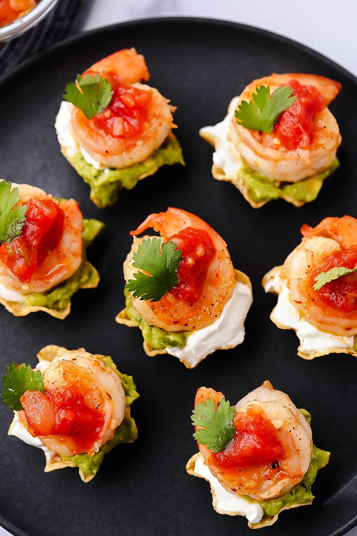 Juicy, marinated shrimp in a tangy honey-lime sauce are nestled in crunchy tortilla scoops and topped with smooth avocado, cool sour cream, and vibrant fresh salsa.