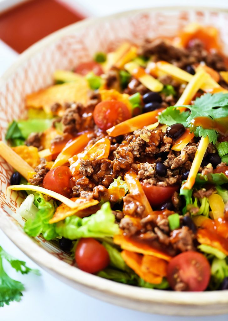 This Doritos Taco Salad is loaded with seasoned ground beef, black beans and of course, Nacho Cheese Doritos. Life-in-the-Lofthouse.com