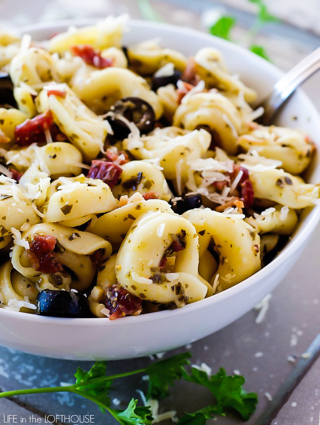 Pesto Tortellini Salad is cheese tortellini pasta coated in pesto, bacon and olives. Life-in-the-Lofthouse.com