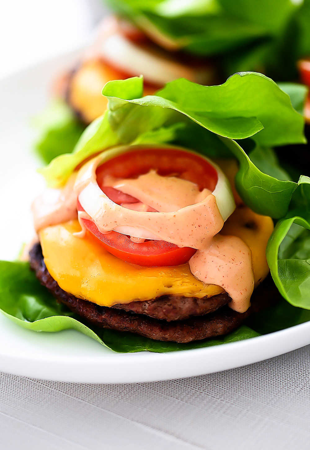 A flavorful burger topped with cheese, tomato, and a mouth-watering spread wrapped in lettuce. Life-in-the-Lofthouse.com