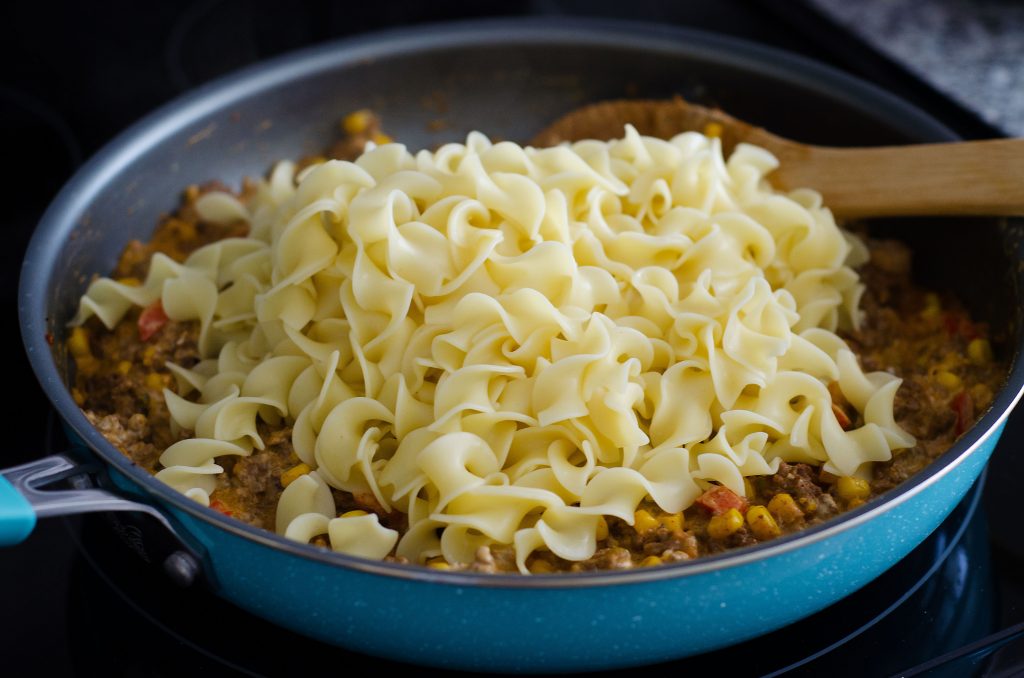 A delicious skillet with noodles, ground beef, olives and red bell peppers with taco seasonings. Life-in-the-Lofthouse.com
