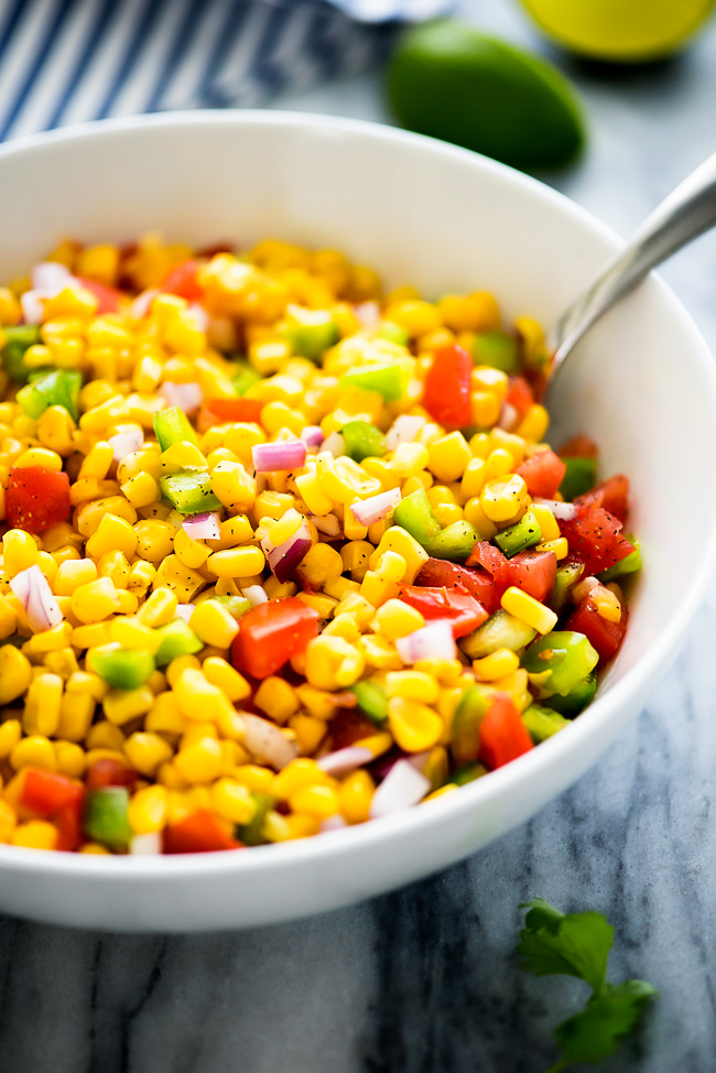 Summer corn salad is a flavorful salad filled with corn, bell peppers, tomato, red onion and fresh cilantro. Life-in-the-Lofthouse.com