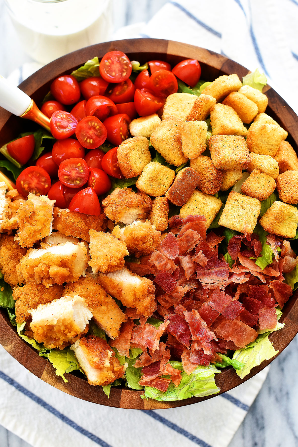 Crispy Chicken BLT Salad is loaded with chicken tenders, lots of chopped bacon, cherry tomatoes and croutons over a bed of romaine lettuce. Life-in-the-Lofthouse.com