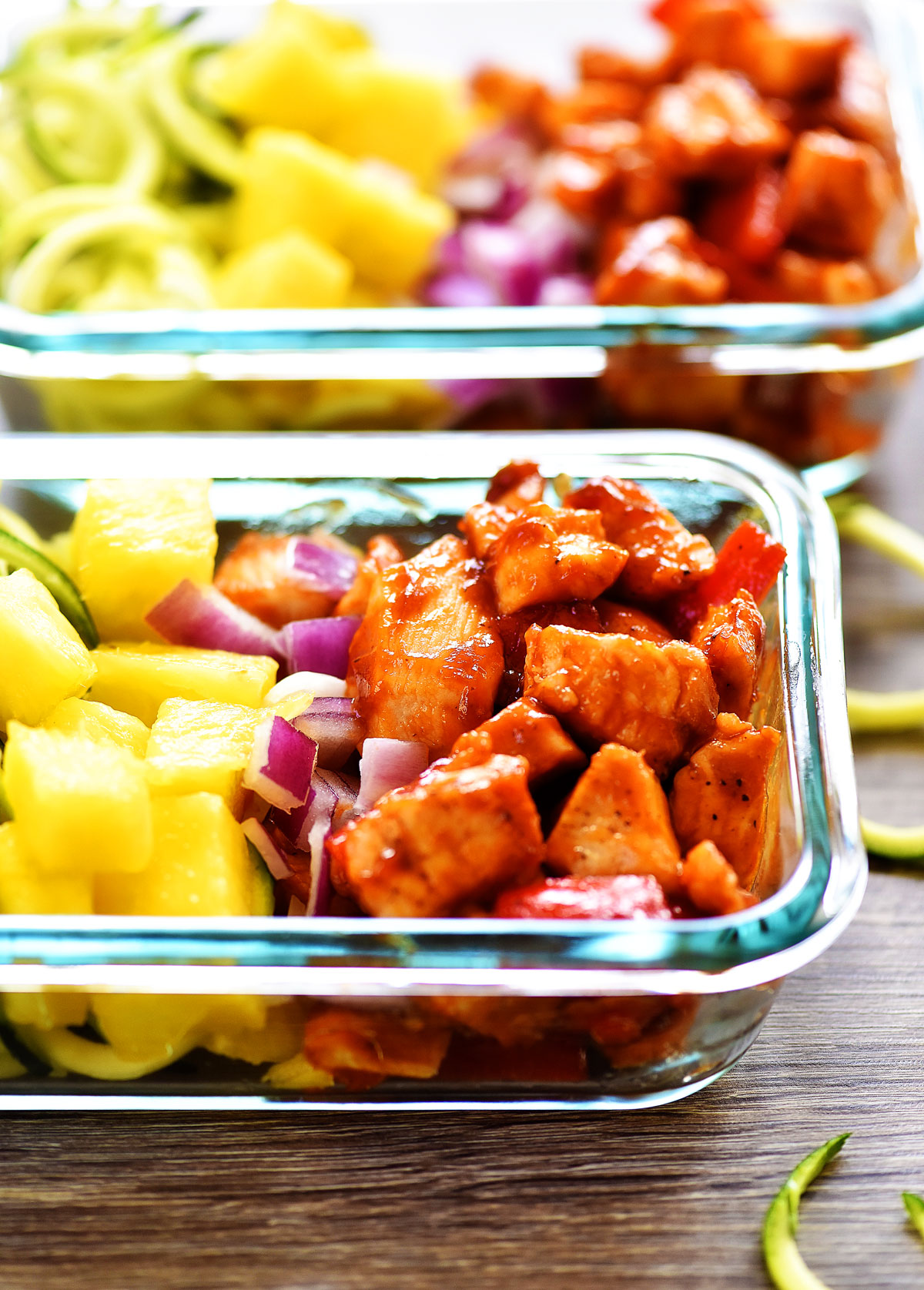 Hawaiian Chicken meal prep bowls are filled with seasoned barbecue chicken, bell pepper, fresh pineapple, red onion and zucchini noodles. Life-in-the-Lofthouse.com