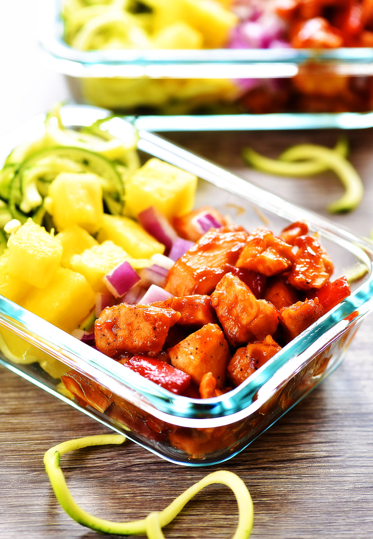 Hawaiian Chicken meal prep bowls are filled with seasoned barbecue chicken, bell pepper, fresh pineapple, red onion and zucchini noodles. Life-in-the-Lofthouse.com