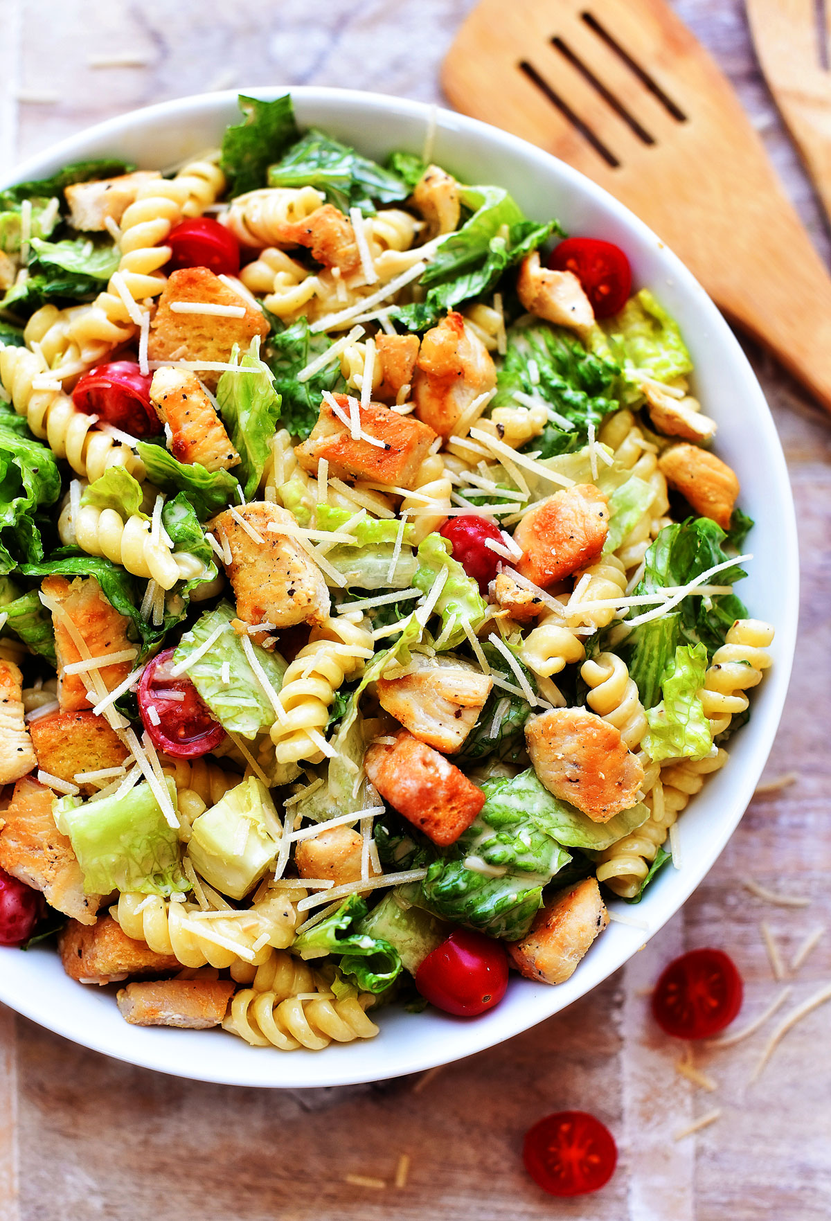 Chicken Caesar Pasta Salad is filled with grilled chicken, rotini pasta, croutons and tomatoes over a bed of romaine lettuce. Life-in-the-Lofthouse.com