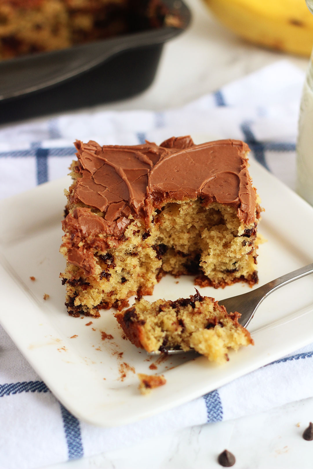Chocolate Chip Banana Cake is a delicious, soft banana cake filled with chocolate chips and topped with a creamy chocolate frosting. Life-in-the-Lofthouse.com