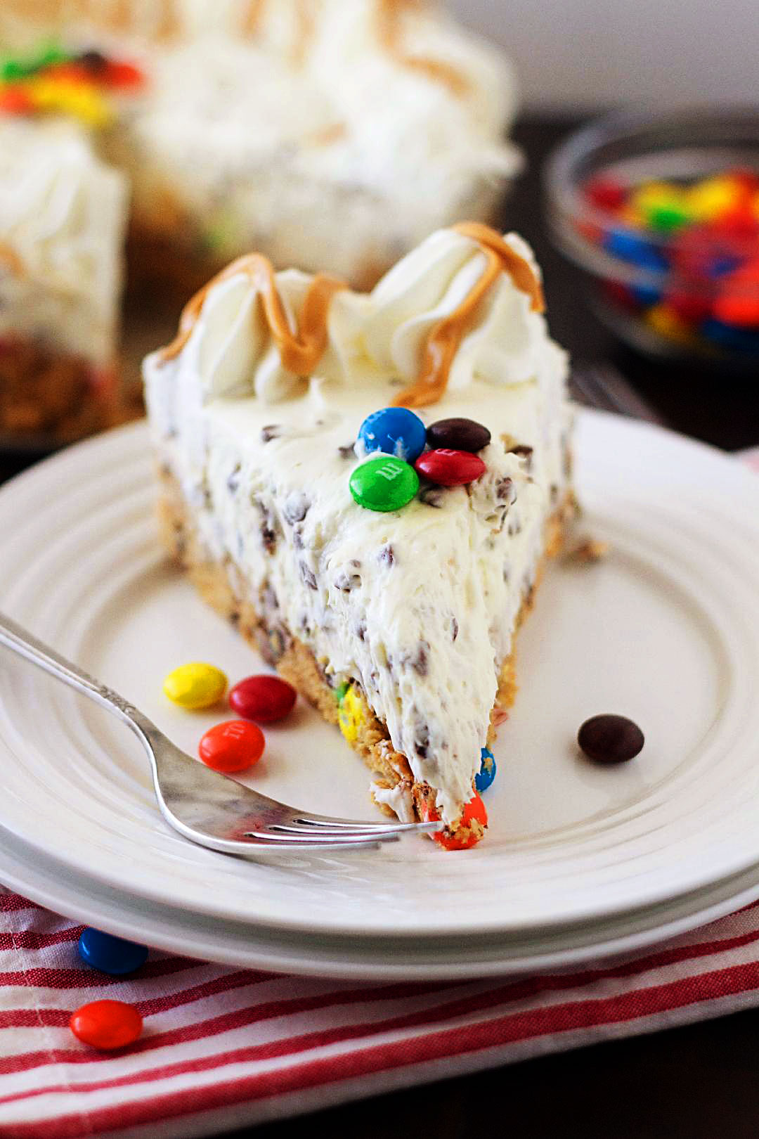 Monster Cookie Dough Cheesecake has a crust that is a&nbsp;monster cookie dough loaded with M&M&rsquo;s and mini chocolate chips and topped with a creamy cheesecake filling loaded with mini chocolate chips. Life-in-the-Lofthouse.com