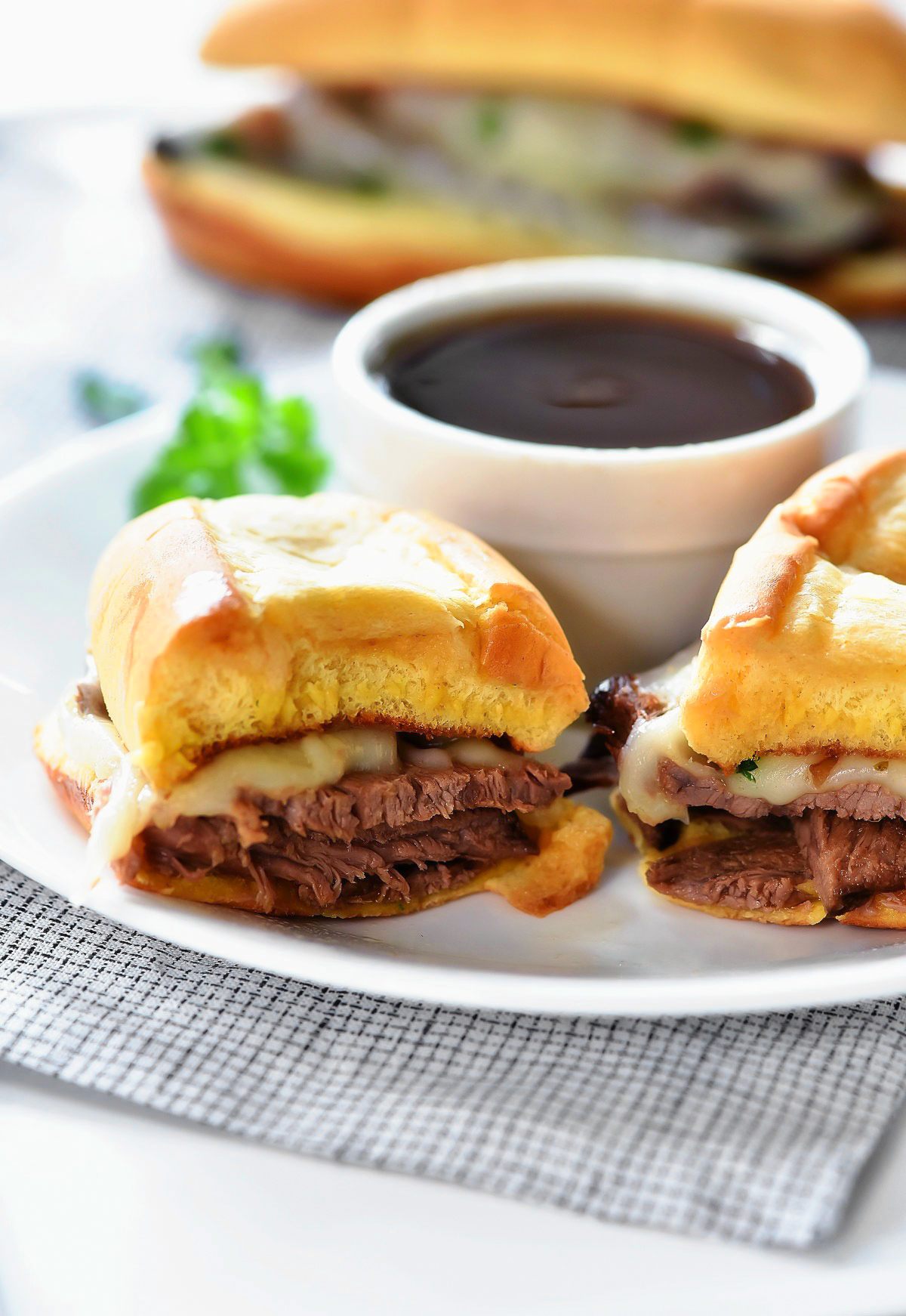 Slow Cooker French Dip Sandwiches are filled with tender slow cooked beef, topped with melty cheese and packed inside a toasty bun. Life-in-the-Lofthouse.com