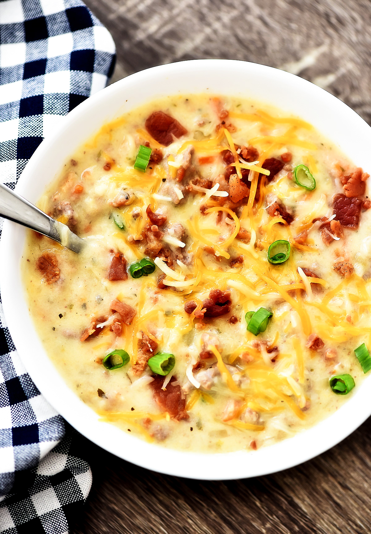 Bacon Cheeseburger soup is slow cooked soup loaded with potatoes, ground beef, cheese and bacon. Life-in-the-Lofthouse.com
