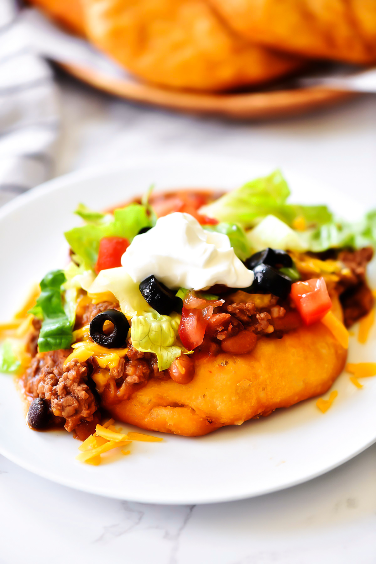 Easy Navajo Tacos are Indian fry breads topped with chili, cheese and all your favorite taco fixings. 