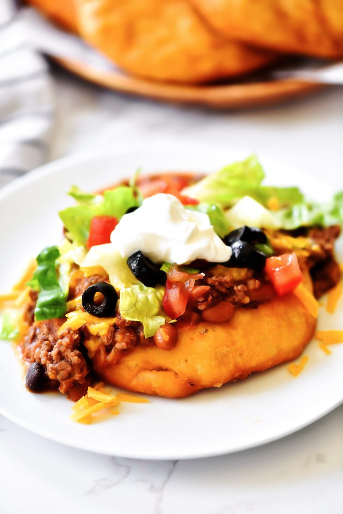 Easy Navajo Tacos are Indian fry breads topped with chili, cheese and all your favorite taco fixings. Life-in-the-Lofthouse.com