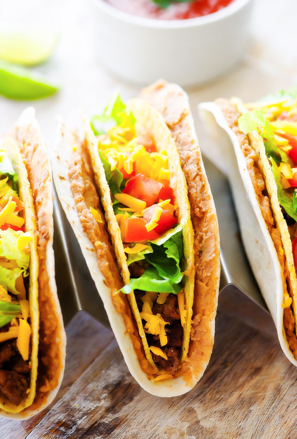 Double Decker Tacos start with a flour tortilla layered with beans, then inside there's a crispy beef taco filled with all your favorite taco toppings. Life-in-the-Lofthouse.com