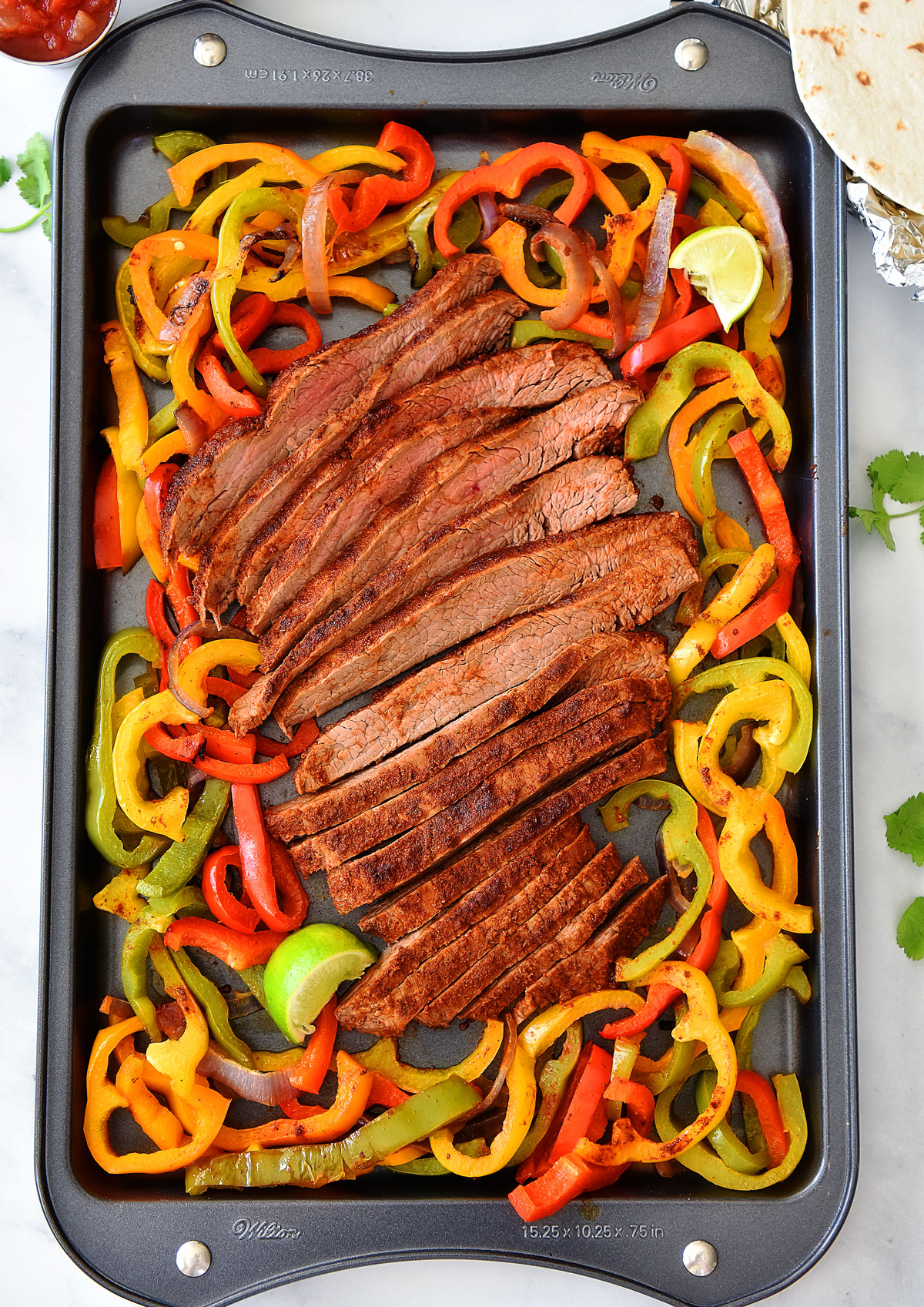 Sheet Pan Steak Fajitas are just like classic fajitas with grilled onions, bell peppers and steak. Life-in-the-Lofthouse.com