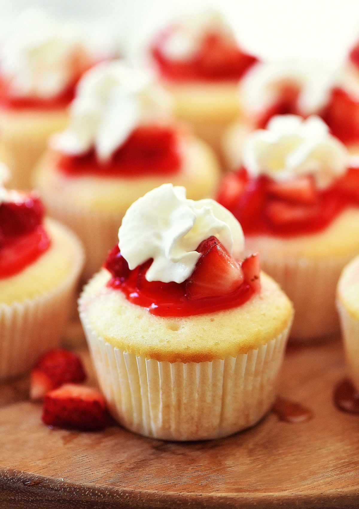 Strawberry Shortcake Cupcakes are white cakes that are light as air and topped with strawberries, glaze and whipped cream. Life-in-the-Lofthouse.com