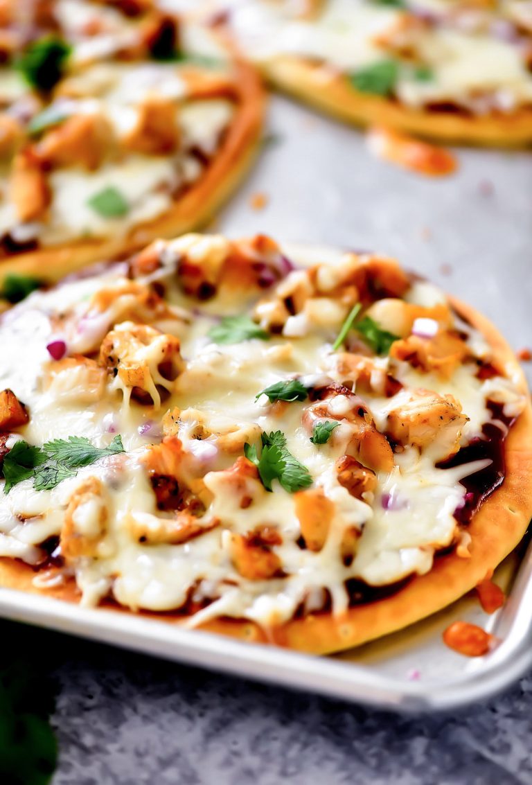 A BBQ chicken flatbread pizza topped with melted cheese, chicken, red onion, cilantro and barbecue sauce on a crispy flatbread crust.