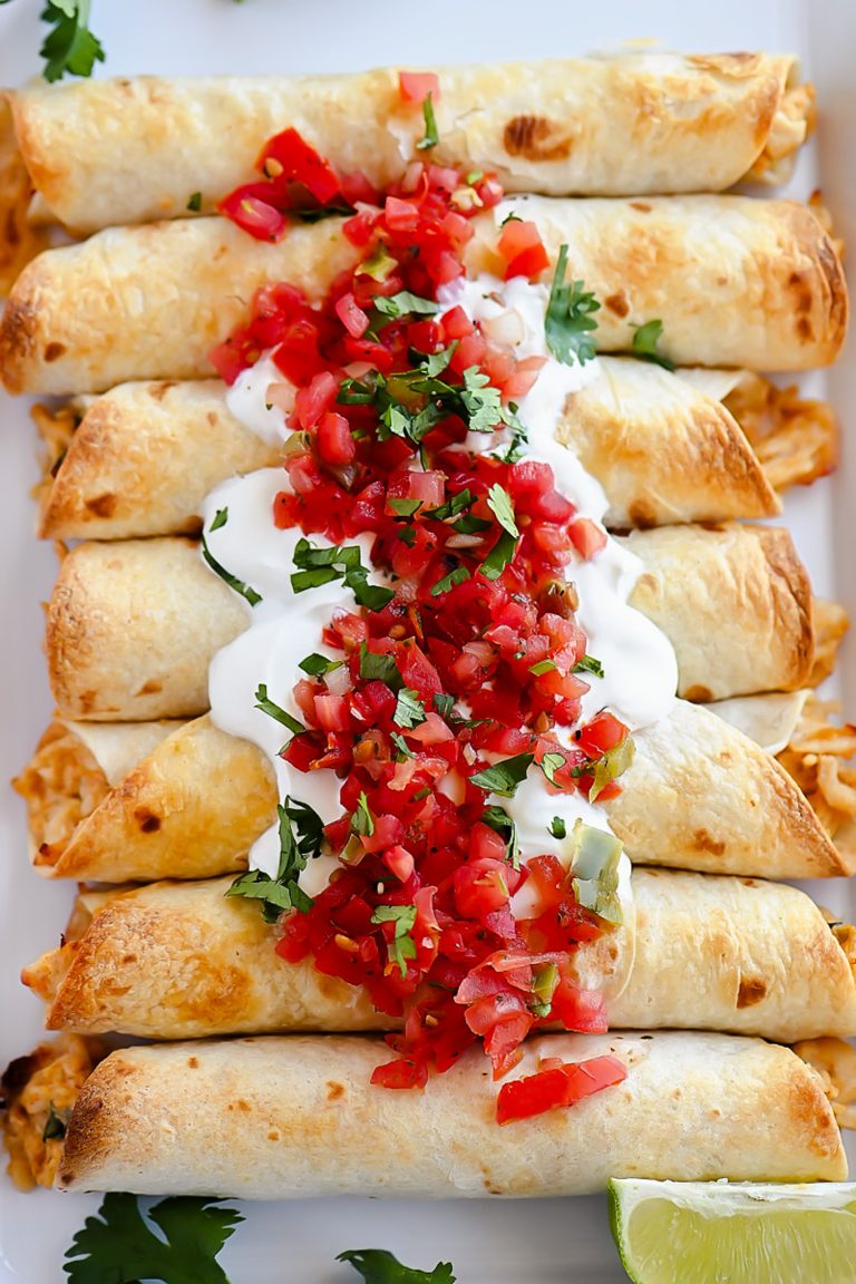 Baked Chicken Taquitos are a crispy flour tortilla wrapped around a warm center of creamy and cheesy Mexican chicken.