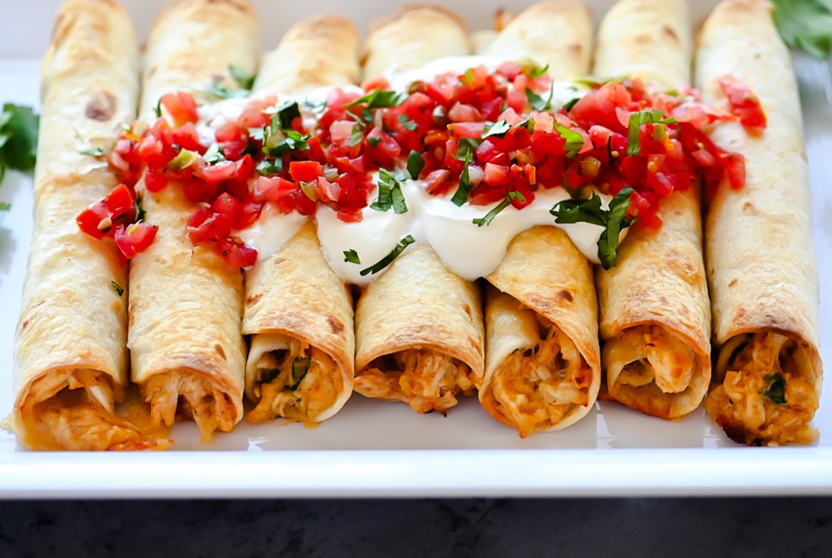 Baked Chicken Taquitos are a crispy flour tortilla wrapped around a warm center of creamy and cheesy Mexican chicken.