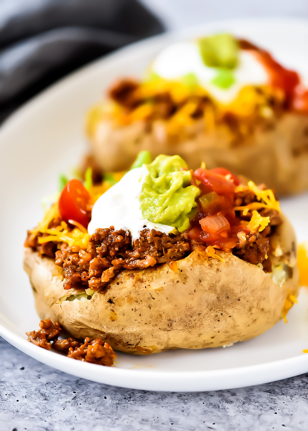 Taco Potatoes are loaded with seasoned ground beef, cheese, lettuce, sour cream and salsa all over a baked potato. Life-in-the-Lofthouse.com