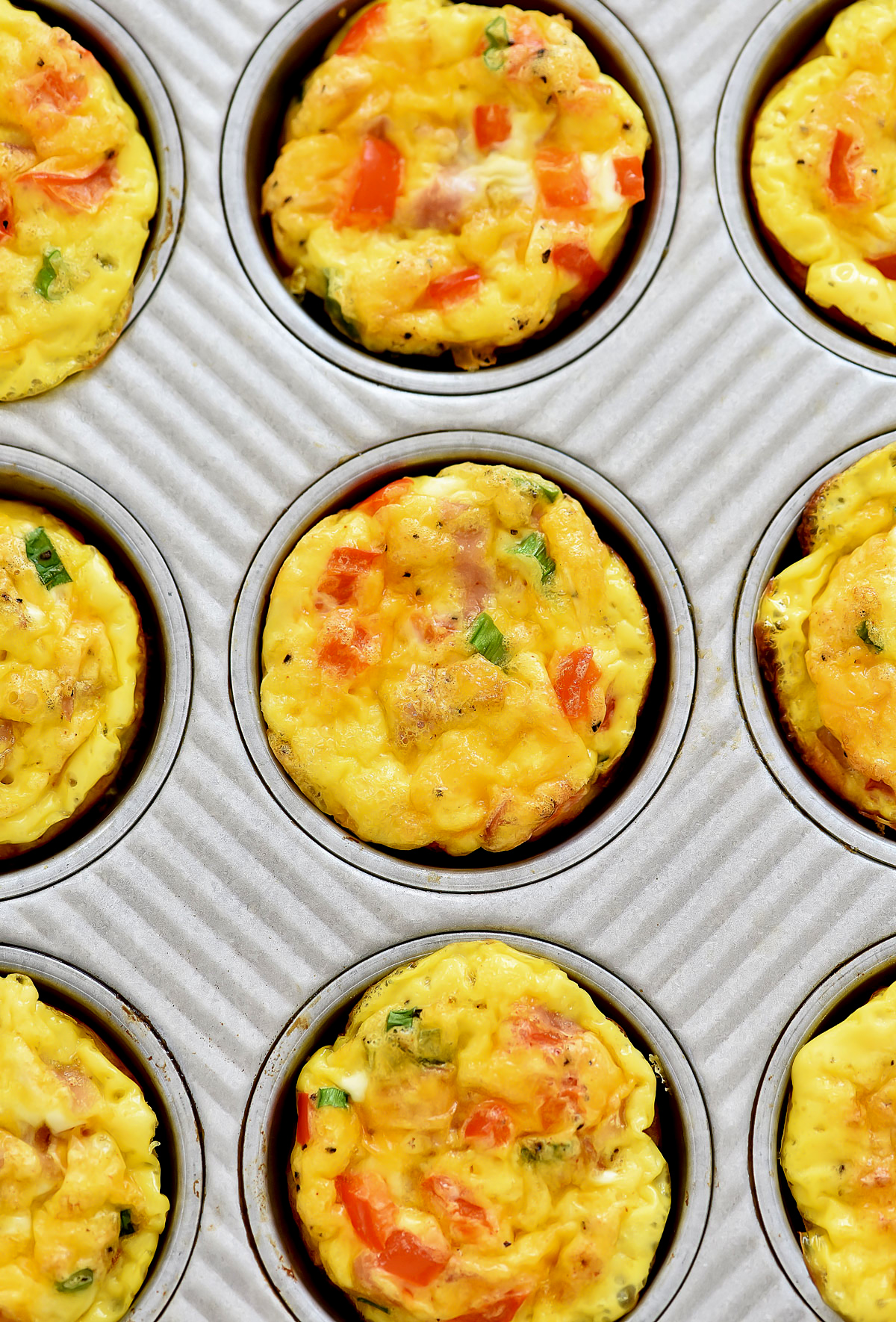 Scrambled Egg Breakfast Muffins are egg muffins filled with ham, green onion cheese and bell pepper. Life-in-the-Lofthouse.com