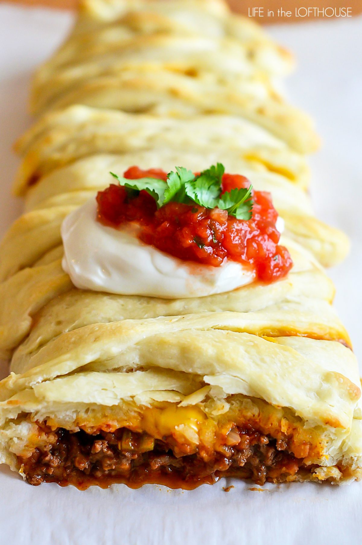 Taco Braid is filled with seasoned ground beef, beans and cheese wrapped up in pizza dough then baked.