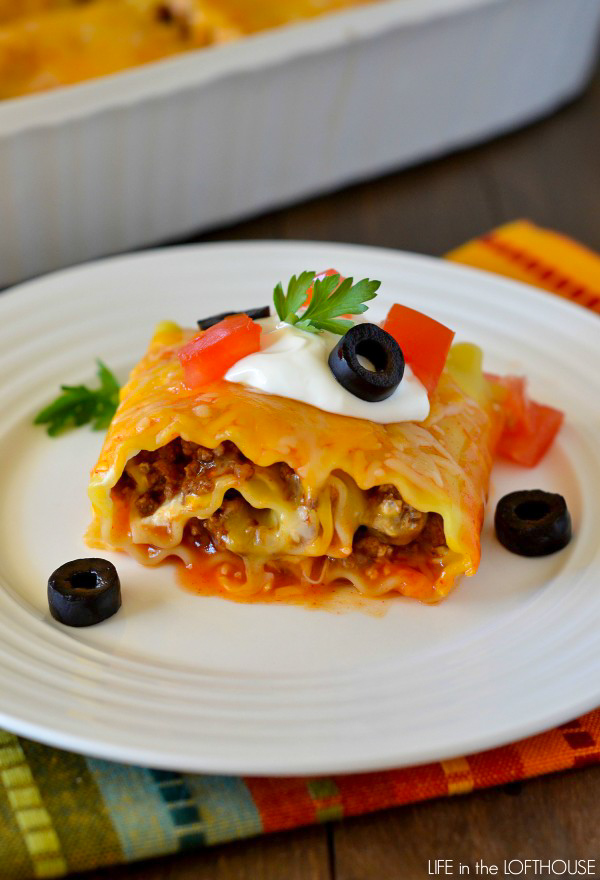 Beef enchilada lasagna roll ups are made up of Beef, enchilada sauce and taco seasoning wrapped up in lasagna noodles and covered in gooey cheese. Life-in-the-Lofthouse.com