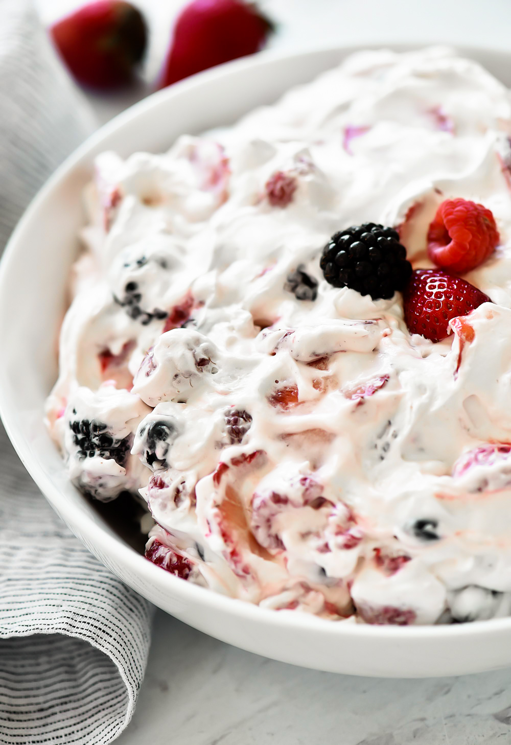 Sliced strawberries, blueberries, blackberries and raspberries covered in a sweet cream cheese fluff. Life-in-the-Lofthouse.com