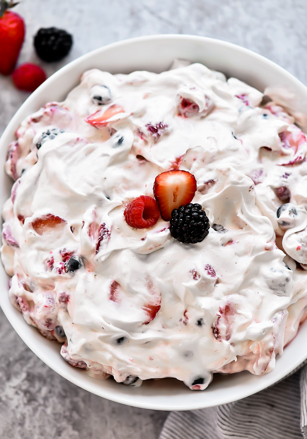 Sliced strawberries, blueberries, blackberries and raspberries covered in a sweet cream cheese fluff. Life-in-the-Lofthouse.com