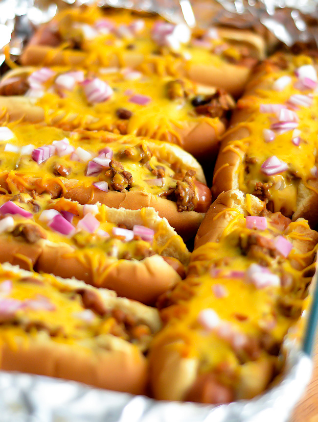Oven-baked Chili Cheese dogs are loaded hot dogs with chili, cheese and onion, baked in the oven. Life-in-the-Lofthouse.com