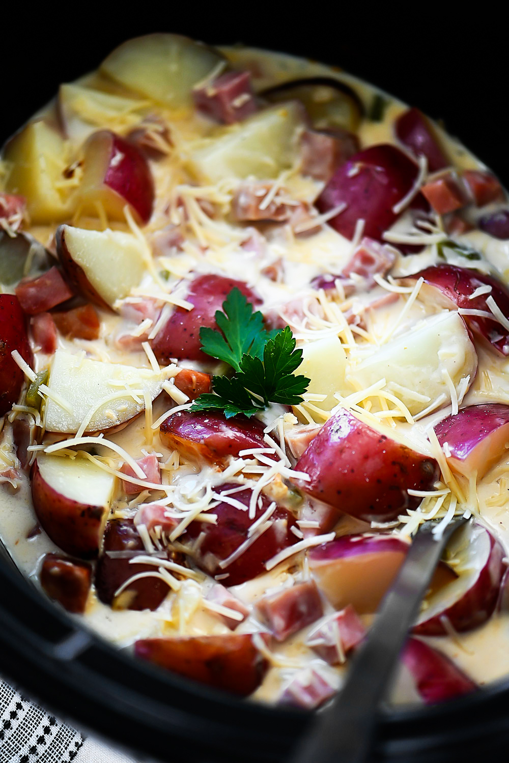 Potatoes, ham and Alfredo sauce slow cook in the crock pot.