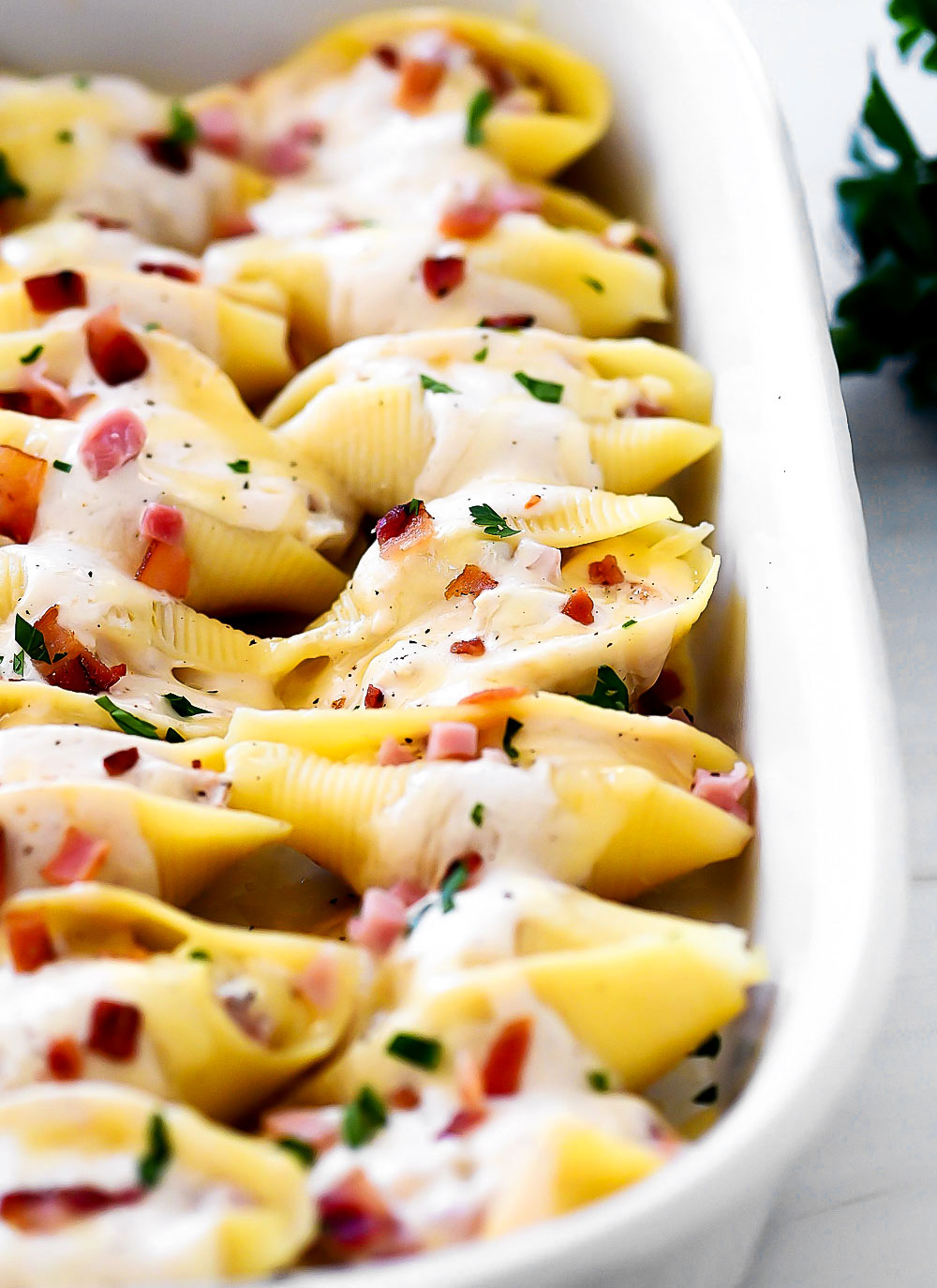 Jumbo pasta shells stuffed with chicken, ham and bacon covered in Alfredo sauce and cheese.