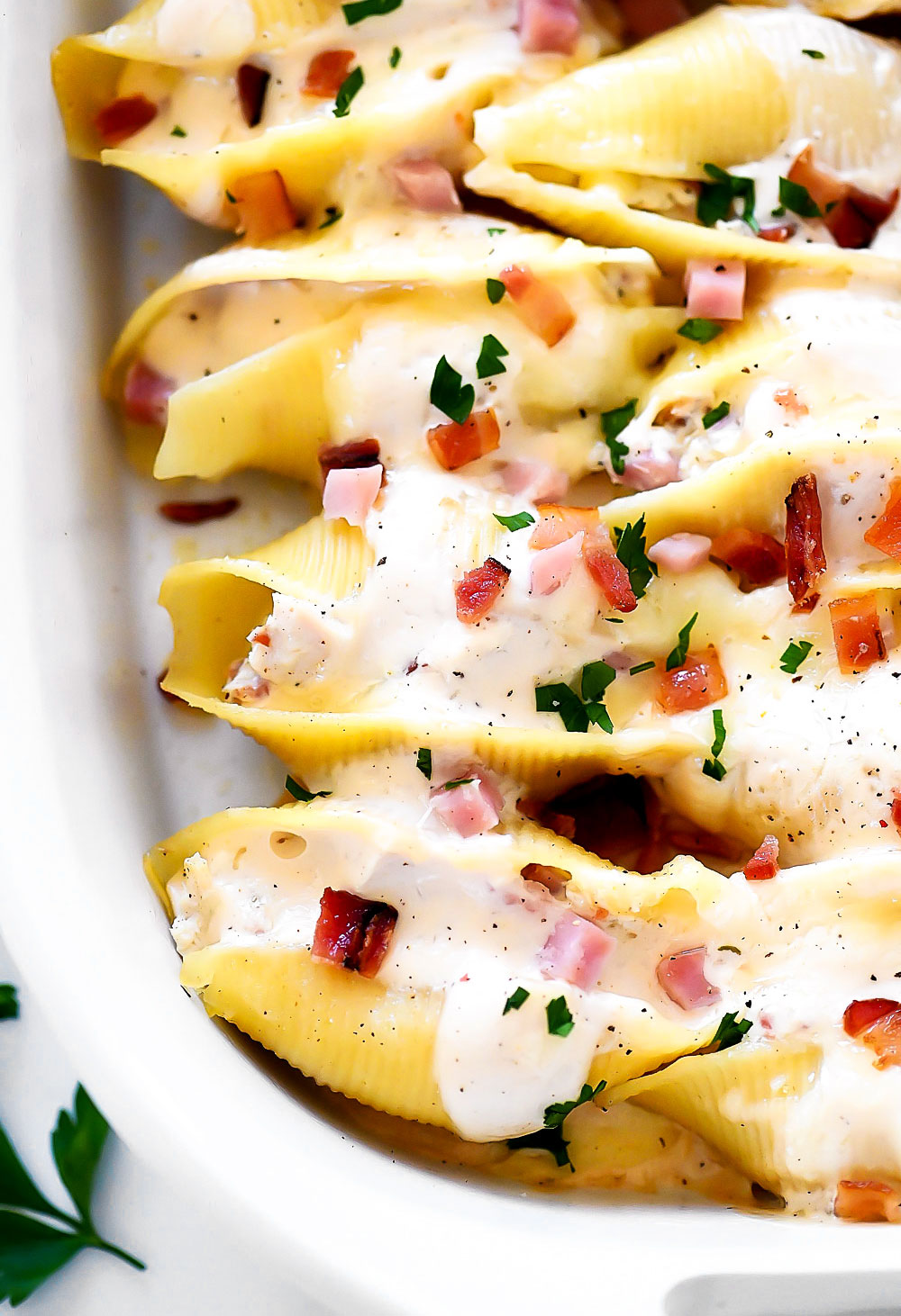 Jumbo pasta shells stuffed with chicken, ham and bacon covered in Alfredo sauce and cheese.