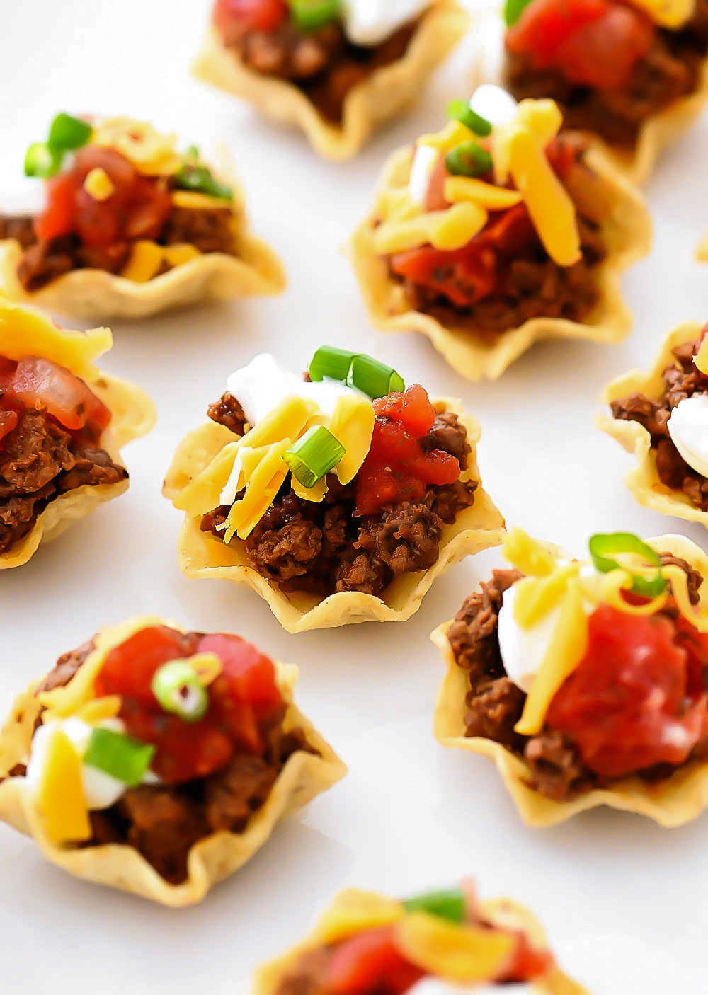 Taco Bites are small tortilla chips topped with taco meat and toppings.