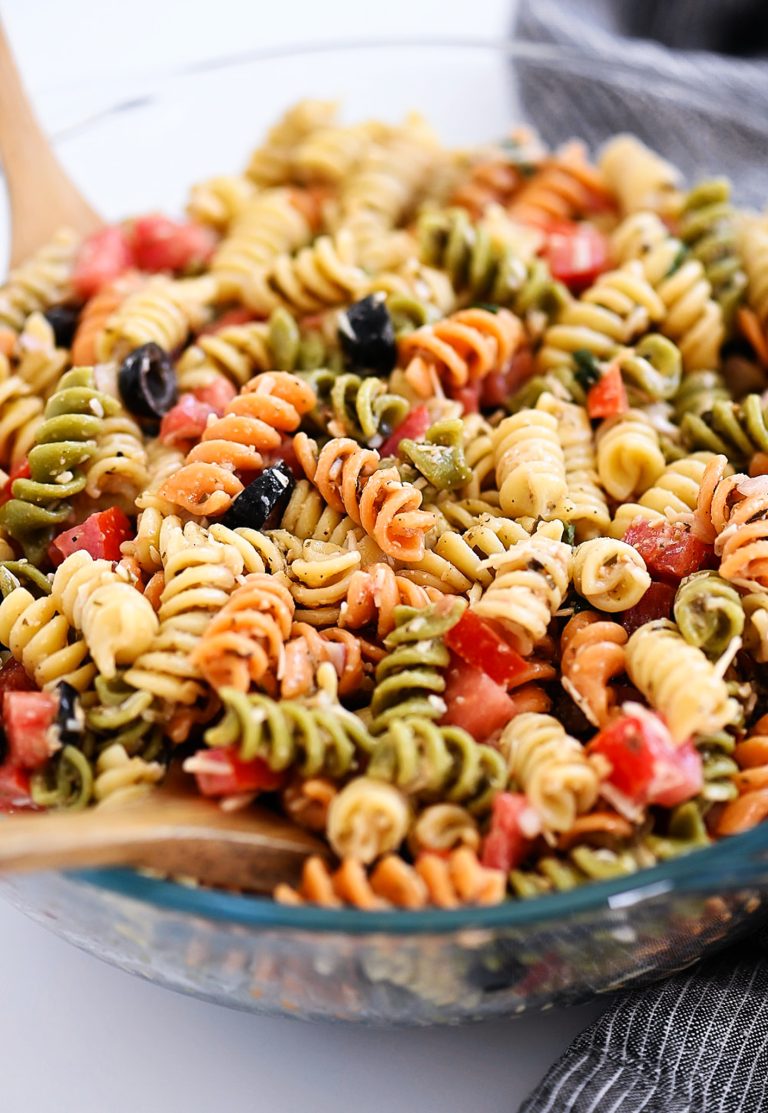 Tri Color Pasta Salad is filled with noodles, fresh veggies, and Parmesan cheese. It’s tossed in a creamy Caesar dressing and basil pesto