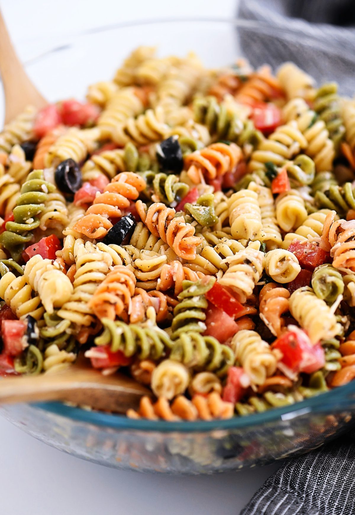 Tri Color Pasta Salad is filled with noodles, fresh veggies, and Parmesan cheese. It&rsquo;s tossed in a creamy Caesar dressing and basil pesto