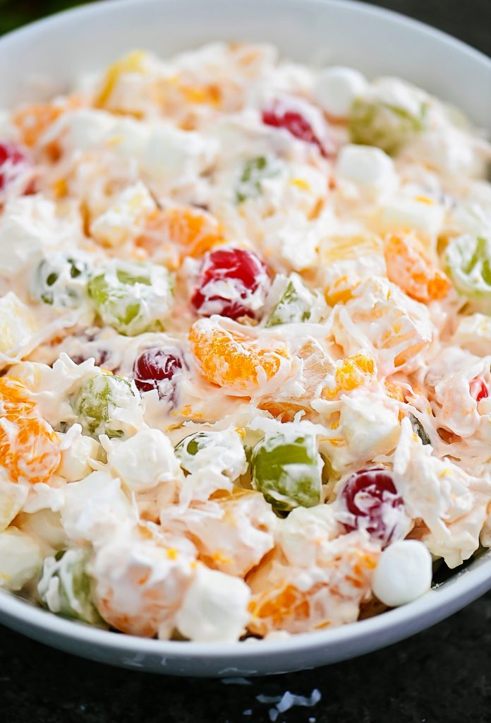 Ambrosia salad has apples, oranges, pineapples and grapes all tossed together in whipped topping and shredded coconut. Life-in-the-Lofthouse.com