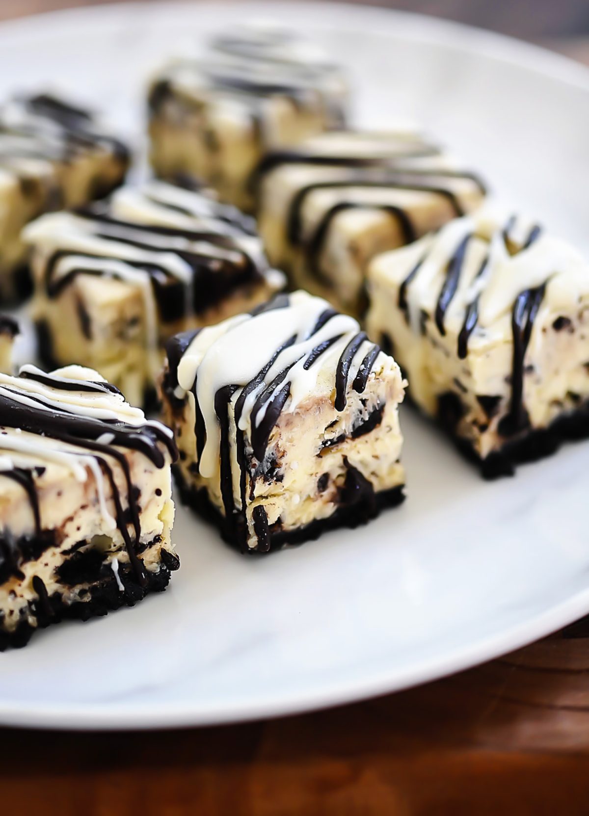 Oreo cheesecake bites are a delicious bite size dessert with an Oreo cookie base and a drizzling of chocolate candy coating. Life-in-the-Lofthouse.com