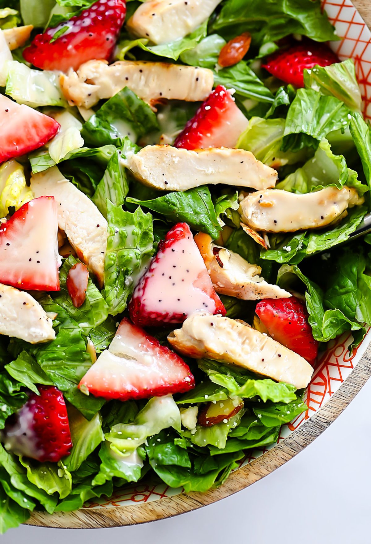 Strawberry Chicken Salad is filled with chopped romaine lettuce, sprinkles of sliced almonds, sliced strawberries and grilled&nbsp;chicken.