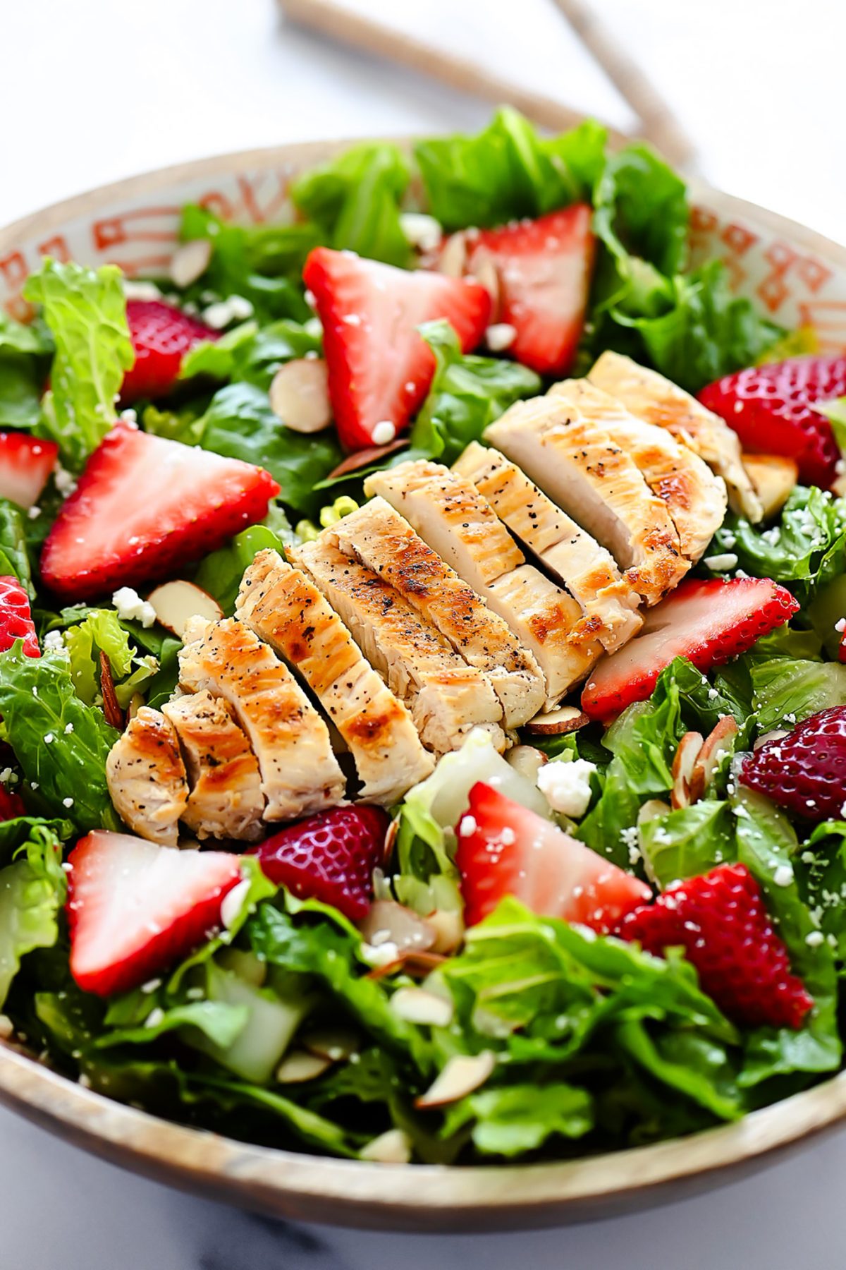 Strawberry Chicken Salad is filled with chopped romaine lettuce, sprinkles of sliced almonds, sliced strawberries and grilled&nbsp;chicken.