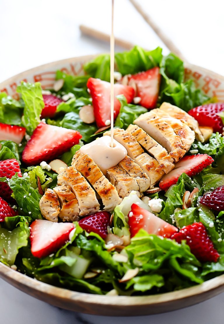 Strawberry Chicken Salad is filled with chopped romaine lettuce, sprinkles of sliced almonds, sliced strawberries and grilled chicken.
