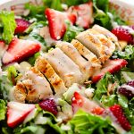 Strawberry Chicken Salad is filled with chopped romaine lettuce, sprinkles of sliced almonds, sliced strawberries and grilled&nbsp;chicken.