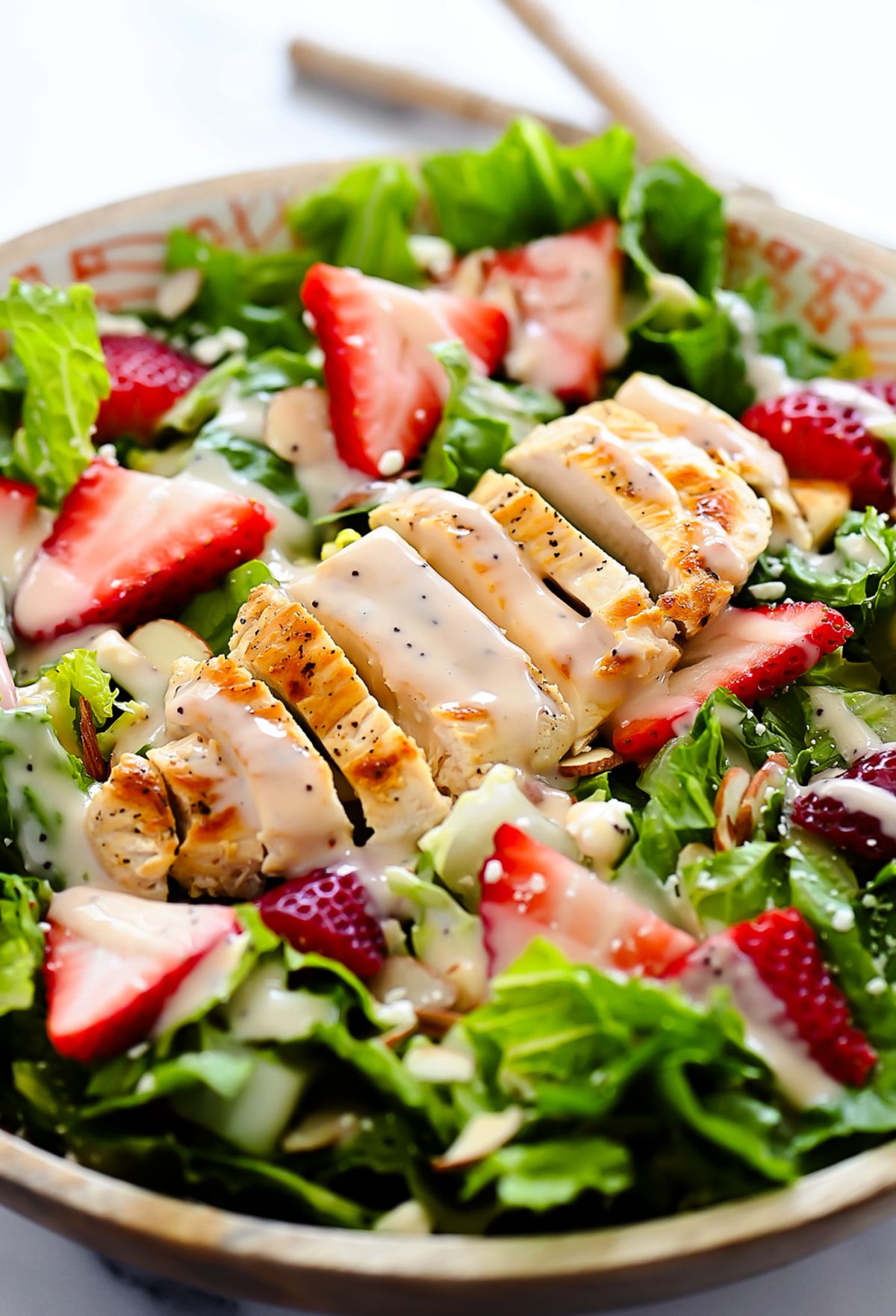 Strawberry Chicken Salad is filled with chopped romaine lettuce, sprinkles of sliced almonds, sliced strawberries and grilled&nbsp;chicken.
