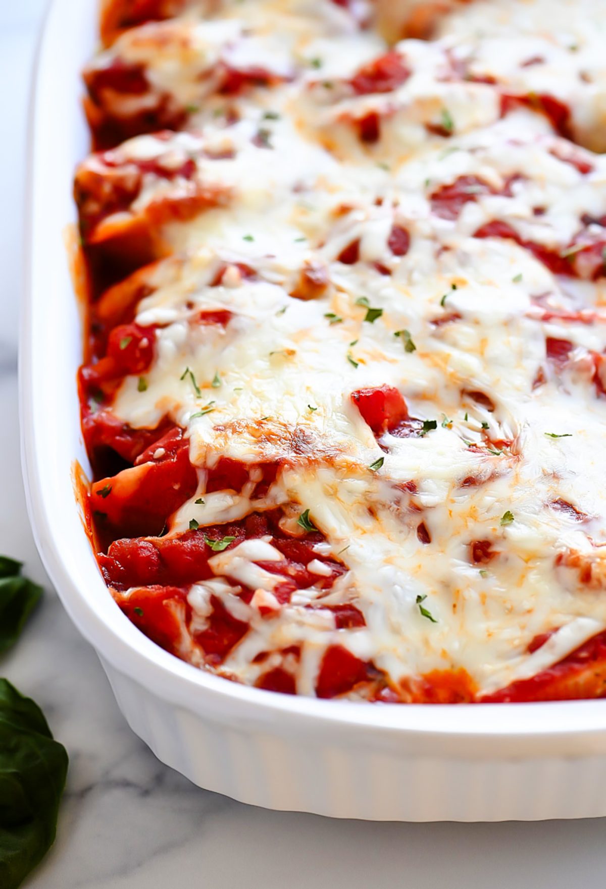 Chicken stuffed shells with pesto and cheese.