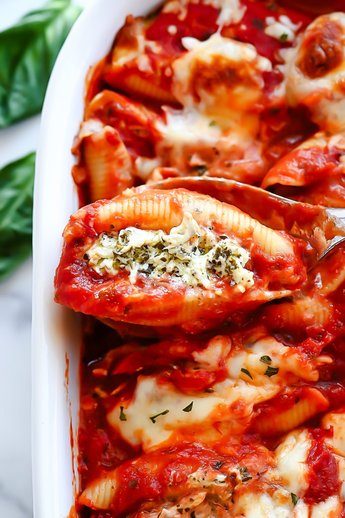 Chicken stuffed shells with pesto and cheese.