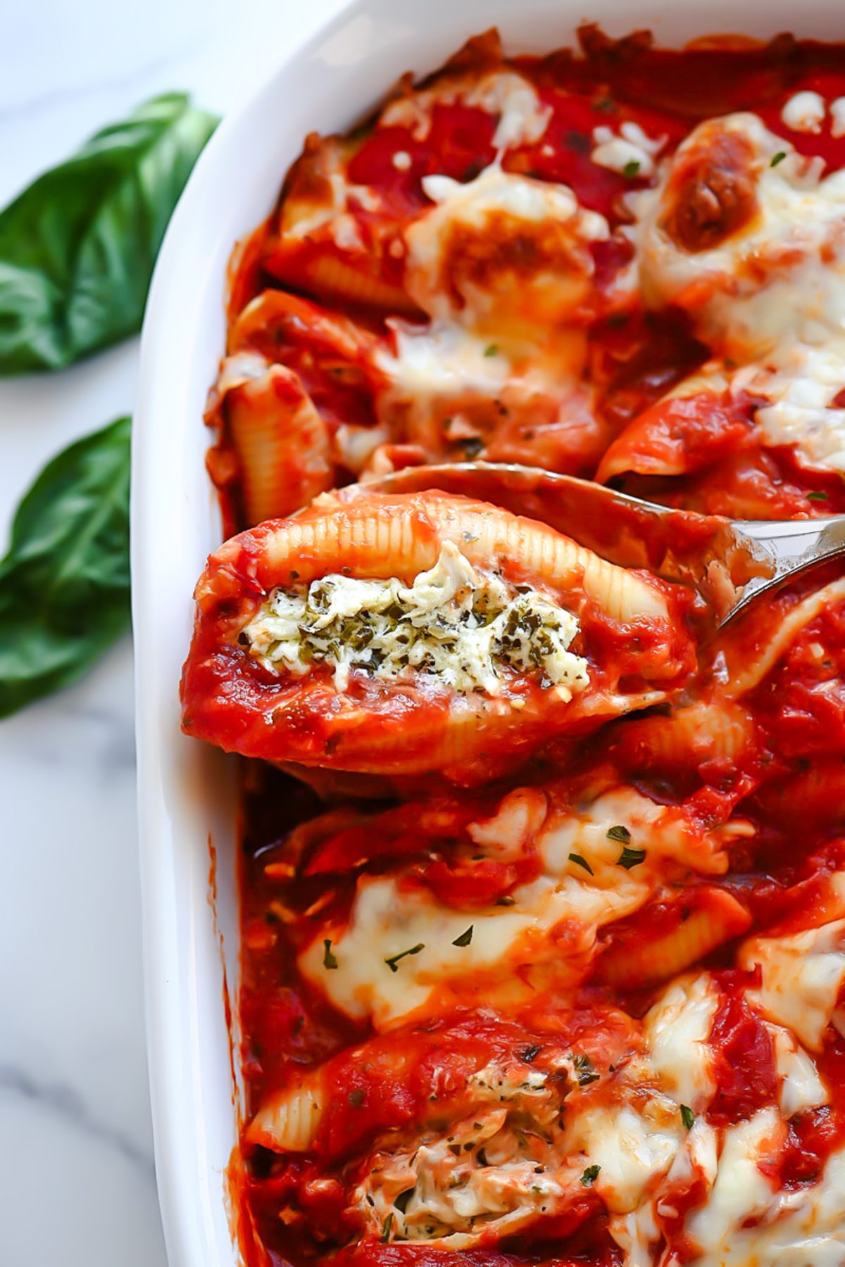 Chicken stuffed shells with pesto and cheese.